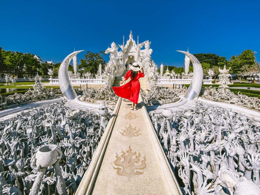 Templo Blanco de Chiang Rai, con sus esculturas blancas y la pasarela central bajo un cielo azul (Tailandia)