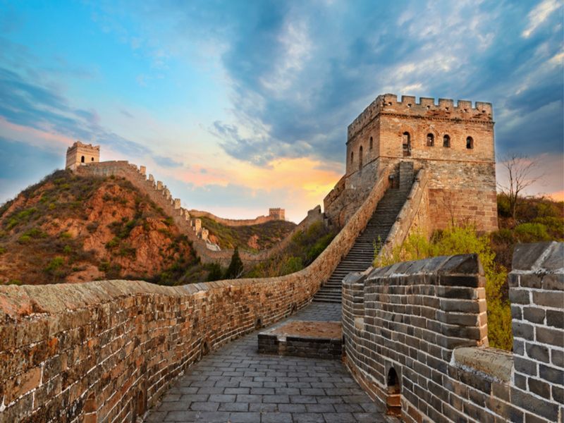 Tramo de la Gran Muralla China al atardecer, con torres y escalera de piedra