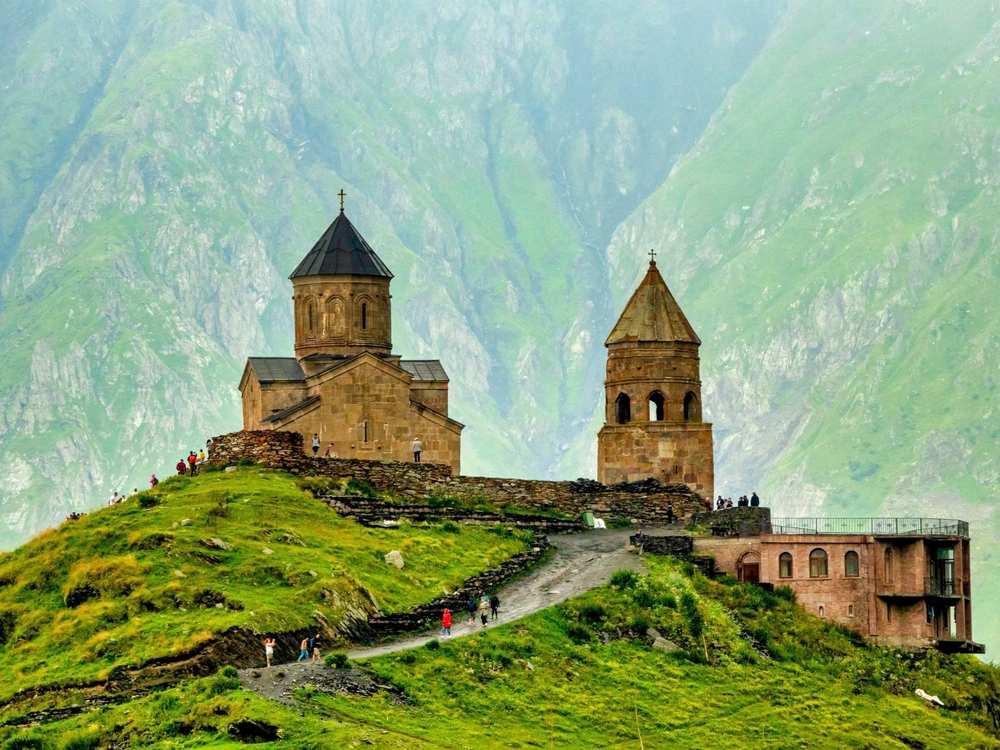 La iglesia de la Trinidad de Gergeti sobre un monte verde en el Cáucaso