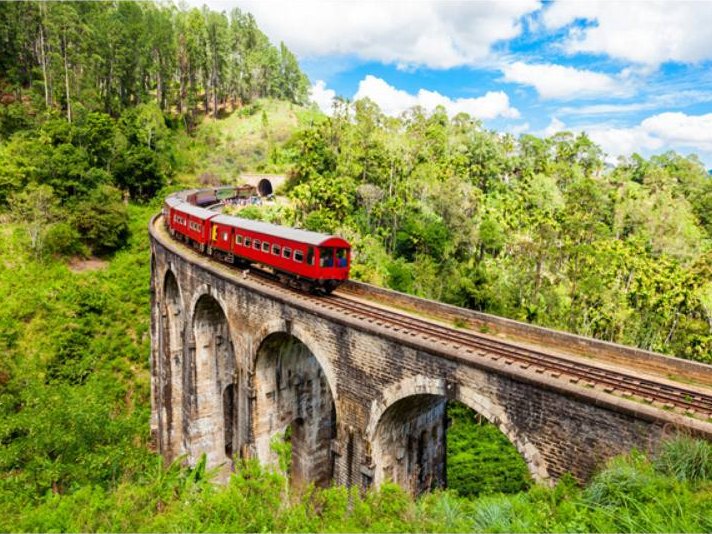Tren rojo cruzando el Puente de los Nueve Arcos entre la selva, Sri Lanka