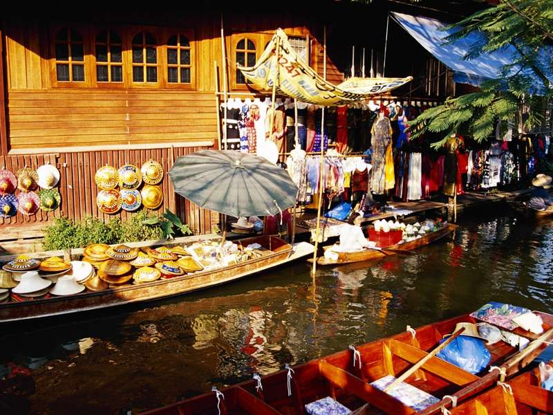 Barcas cargadas de fruta y puestos en el mercado flotante de Damnoen Saduak